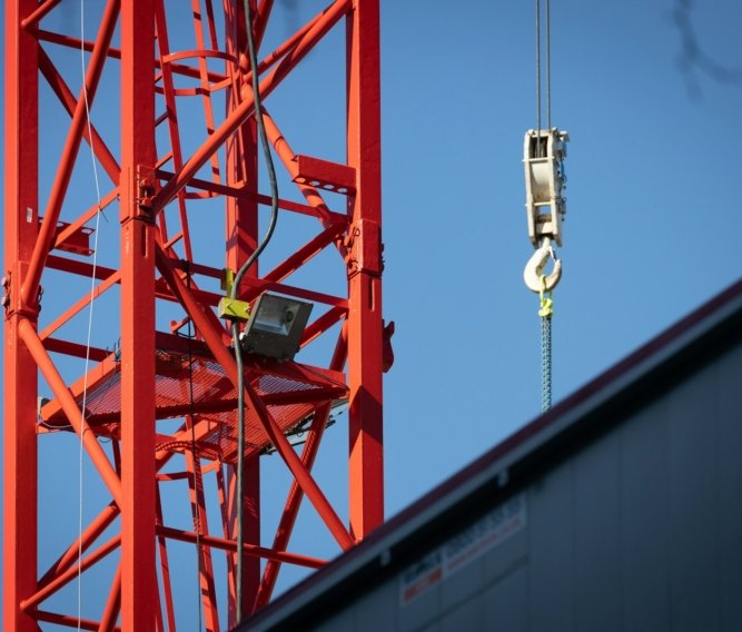 a crane that is hanging from the side of a building