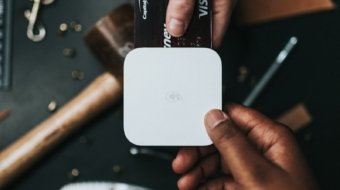 person holding Visa card and white device
