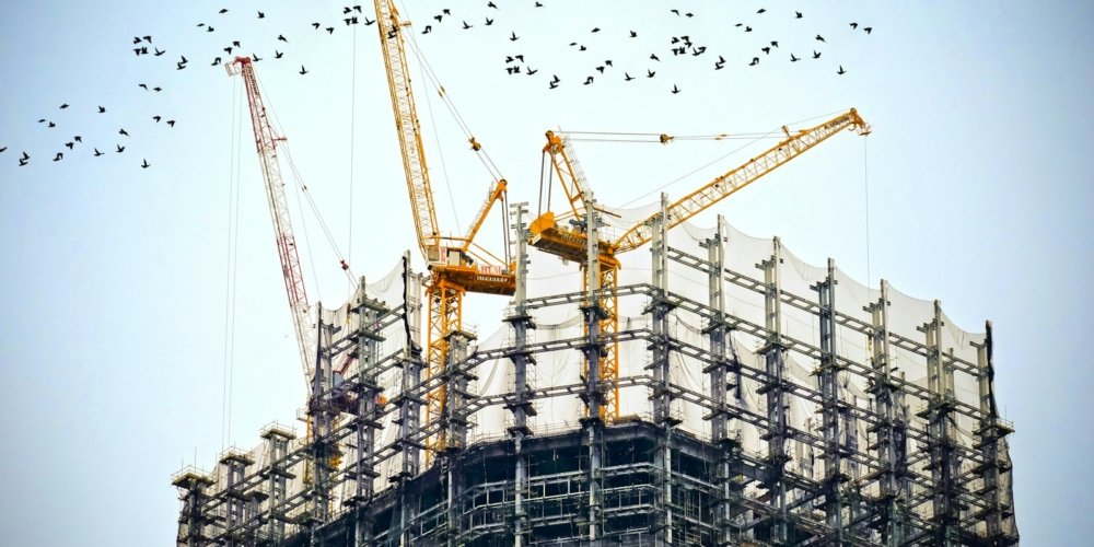 low angle photography of cranes on top of building